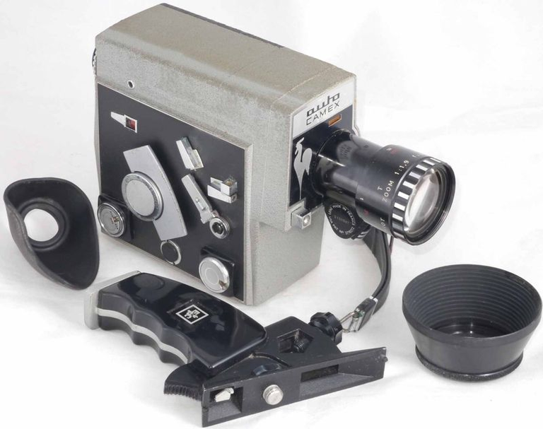 Caméra Pathé Auto Camex grise avec son oeilleton de viseur, son paresoleil et sa poignée
