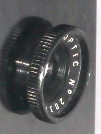 L’objectif FEXAR OPTIC porte le numéro 2037. Ce numéro a été largement employé chez FEX INDO sur des appareils photos. Quant au numéro, c’est une référence et non pas un numéro de série (tous les objectifs de tous les projecteurs portent ce numéro). La couronne de l’objectif est en Bakélite, tout comme son corps. Devant la lentille frontale se trouve un anneau métallique non peint.