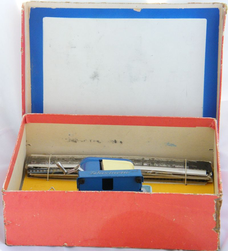 Duxinette bleue et jaune, l'intérieur du couvercle de la boîte d'origine fait office d'écran
